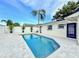 Backyard featuring a swimming pool surrounded by palm trees and a privacy fence at 1972 Briarwood St, Dunedin, FL 34698