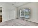 Bedroom with neutral carpet, a large window overlooking the pool and a double door closet at 22431 Panther Run Ct, Land O Lakes, FL 34639