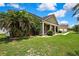 Well-manicured front lawn with palm trees, shrubs, and a sidewalk to the front door at 22431 Panther Run Ct, Land O Lakes, FL 34639