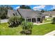 Charming single-Gathering home features a manicured lawn with mature landscaping and a covered front porch at 22431 Panther Run Ct, Land O Lakes, FL 34639
