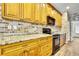 The kitchen features a brick backsplash, granite countertops, and modern black appliances at 22431 Panther Run Ct, Land O Lakes, FL 34639