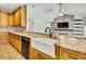 Charming kitchen featuring granite countertops, wood cabinets, and a farmhouse sink at 22431 Panther Run Ct, Land O Lakes, FL 34639