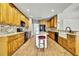 Spacious kitchen with honey colored cabinetry, granite countertops, and an island with seating at 22431 Panther Run Ct, Land O Lakes, FL 34639