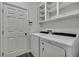 Laundry room showcasing a modern washer and dryer set with wall shelving at 22431 Panther Run Ct, Land O Lakes, FL 34639