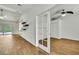Bright living room with wood-look tile floors, modern ceiling fan, and open layout to the kitchen at 22431 Panther Run Ct, Land O Lakes, FL 34639