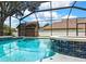 Inviting screened pool with a stunning waterfall feature, set against a picturesque view of the backyard at 22431 Panther Run Ct, Land O Lakes, FL 34639