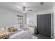 Modern bedroom with a ceiling fan, grey wood floors, neutral color, and view to the outdoors at 22716 Penny Loop, Land O Lakes, FL 34639