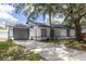 Home's facade showcasing a gray garage door, concrete driveway, fresh paint and manicured landscaping at 22716 Penny Loop, Land O Lakes, FL 34639