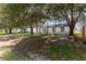 Home exterior featuring a manicured front lawn and an assortment of mature trees at 22716 Penny Loop, Land O Lakes, FL 34639