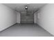 Clean garage featuring epoxy floors, updated lighting, and large garage door at 22716 Penny Loop, Land O Lakes, FL 34639