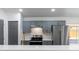Modern kitchen features gray cabinets, stainless steel appliances, and gold hardware at 22716 Penny Loop, Land O Lakes, FL 34639