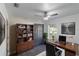 Home office with a dark wood desk, built-in bookshelf, and ample natural light at 22716 Penny Loop, Land O Lakes, FL 34639
