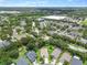 An aerial view captures a community with well-maintained homes, surrounded by lush greenery and nearby commercial areas at 2544 Rosehaven Dr, Wesley Chapel, FL 33544