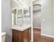 Powder room with wood vanity, sink, mirror, and adjacent doorway leading to the hallway at 2544 Rosehaven Dr, Wesley Chapel, FL 33544