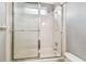 Bathtub with shower, glass door, white tile, and bright lighting for a clean look at 2544 Rosehaven Dr, Wesley Chapel, FL 33544