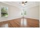 Spacious bedroom with hardwood floors, tray ceilings and two windows offering outdoor views at 2544 Rosehaven Dr, Wesley Chapel, FL 33544