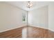This bedroom features hardwood floors, a window with blinds, and a modern light fixture at 2544 Rosehaven Dr, Wesley Chapel, FL 33544