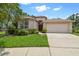 Inviting single-story home featuring a two-car garage and well-maintained landscaping on a bright day at 2544 Rosehaven Dr, Wesley Chapel, FL 33544