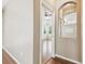 Hallway showing archway mirror with a view into the bedroom, and hardwood floors at 2544 Rosehaven Dr, Wesley Chapel, FL 33544