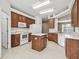 A complete kitchen features an island, wood cabinets, and white appliances with an open layout at 2544 Rosehaven Dr, Wesley Chapel, FL 33544