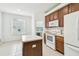 Bright kitchen featuring white appliances, wood cabinets, and access to the laundry room at 2544 Rosehaven Dr, Wesley Chapel, FL 33544