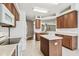 Open kitchen boasts wood cabinetry, an island, and seamless flow into the adjacent spaces at 2544 Rosehaven Dr, Wesley Chapel, FL 33544