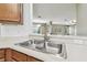 A stainless steel kitchen sink overlooks the living area through a pass-through window at 2544 Rosehaven Dr, Wesley Chapel, FL 33544