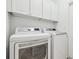 Functional laundry room features white appliances and cabinets for storage and organization at 2544 Rosehaven Dr, Wesley Chapel, FL 33544