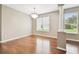 A bright and airy living space featuring a decorative column, hardwood floors and large windows at 2544 Rosehaven Dr, Wesley Chapel, FL 33544