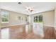 Open-concept living room with gleaming hardwood floors, neutral walls, and glass sliding doors to the backyard at 2544 Rosehaven Dr, Wesley Chapel, FL 33544