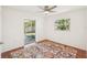 Bright bedroom with hardwood floors, ceiling fan, access to screened-in patio, and a natural outdoor view at 2896 Grand Cayman St, Sarasota, FL 34231