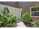 Charming walkway to front door flanked by tropical landscaping at 2896 Grand Cayman St, Sarasota, FL 34231
