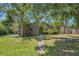 Single-story home with a long walkway to the green front door surrounded by mature trees and green lawn at 2896 Grand Cayman St, Sarasota, FL 34231