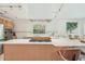 Bright kitchen featuring an island cooktop, stainless steel range hood, and a scenic window view at 2896 Grand Cayman St, Sarasota, FL 34231
