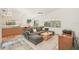 Open-concept living room next to kitchen with tile floors, gray sofa, wood table and art on the wall at 2896 Grand Cayman St, Sarasota, FL 34231