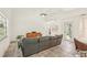Living room with a gray sofa, tiled floor, ceiling fan and glass door out to the backyard at 2896 Grand Cayman St, Sarasota, FL 34231