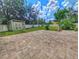 Spacious backyard featuring stone paver patio, storage shed, and lush green lawn at 29916 Cedar Waxwing Dr, Wesley Chapel, FL 33545