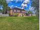 Wide backyard with white fence, stone paver patio, and mature trees at 29916 Cedar Waxwing Dr, Wesley Chapel, FL 33545