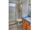 Bathroom features a shower with sliding glass door, wood cabinets and blue countertop at 29916 Cedar Waxwing Dr, Wesley Chapel, FL 33545