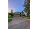 Two-story home with a three-car garage, brick driveway, and manicured landscaping at 29916 Cedar Waxwing Dr, Wesley Chapel, FL 33545