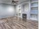 Bright living room featuring fireplace, arched alcoves, wood-look floors, and ceiling fan at 29916 Cedar Waxwing Dr, Wesley Chapel, FL 33545