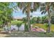 Waterfront backyard featuring a tranquil pond, palm trees, dock and an inviting outdoor seating area at 3156 Depew Ave, Port Charlotte, FL 33952