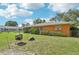 Well-maintained backyard featuring lush grass and mature landscaping with a fire pit at 3156 Depew Ave, Port Charlotte, FL 33952
