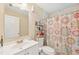 This bathroom features a single sink vanity, tile flooring, a shower-tub combination with a curtain and ample storage shelves at 3156 Depew Ave, Port Charlotte, FL 33952