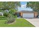 Charming single-story home with a well-maintained lawn, mature trees, and a convenient attached two-car garage at 3156 Depew Ave, Port Charlotte, FL 33952