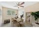 A bright home office with a ceiling fan, two windows, a modern desk, a large mirror, and a plant for a pleasant work environment at 3156 Depew Ave, Port Charlotte, FL 33952
