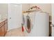 A functional laundry room featuring a washer, dryer, storage shelf, tile flooring, and convenient access to a utility area at 3156 Depew Ave, Port Charlotte, FL 33952