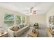 Bright living room with neutral tones, large windows, ceiling fan and comfortable seating at 3156 Depew Ave, Port Charlotte, FL 33952