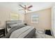 A staged primary bedroom features a ceiling fan, neutral walls, a window, carpet flooring, and a comfortable bed at 3156 Depew Ave, Port Charlotte, FL 33952