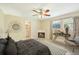 A staged primary bedroom features a ceiling fan, neutral walls, a window, tile flooring, and a comfortable bed at 3156 Depew Ave, Port Charlotte, FL 33952